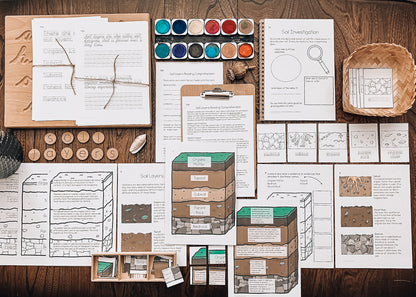 Educational materials on a wooden surface including papers, models, and tools.